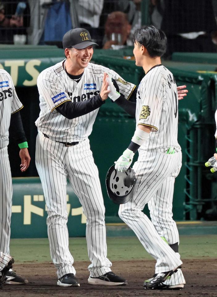 　オリックスに勝利しサヨナラ打を放った木浪（右）を迎える藤川監督＝７日