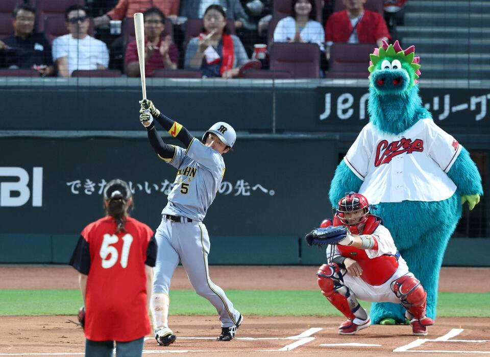 ９月１８日の対広島戦、始球式で打席に立つ近本とスラィリー（右上）