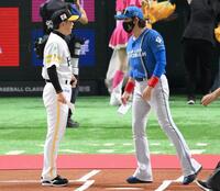 　メンバー表交換時、小久保監督（左）に話しかける新庄監督（１６日）