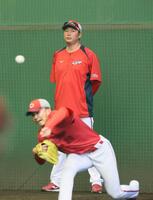 　ブルペンで腕を振る辻を見守る新井監督