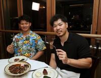 　肉料理を楽しむ佐藤輝（右）と森下（撮影・田中太一）