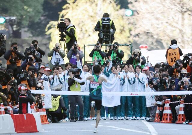 　ゴールするアンカー折田（中央）を迎える青学大の選手ら＝３日