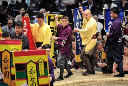 　懸賞を持って土俵をまわる呼び出しの大将（中央）＝２２日、エディオンアリーナ大阪