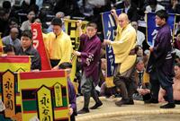 　懸賞を持って土俵をまわる呼び出しの大将（中央）＝２２日、エディオンアリーナ大阪