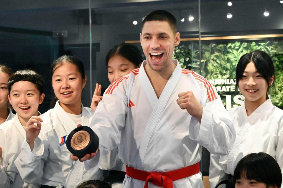 　返還された銅メダルを手に、笑顔で写真に納まるスタニスラフ・ホルナさん