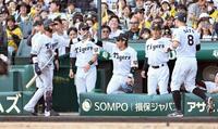 　９日ＤｅＮＡ戦の６回、犠飛を放った木浪（左）はナインに迎えられる。右は生還した佐藤輝