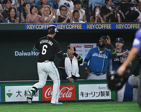 ベンチで全パの出場選手たちとタッチを交わすロッテ・西川史礁（左）＝２８日、東京ドーム（撮影・開出牧）