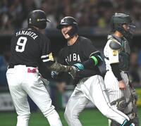 弾けるような笑顔でソフトバンク・柳田悠岐（左）とタッチを交わすロッテ・西川史礁＝２８日、東京ドーム（撮影・開出牧）