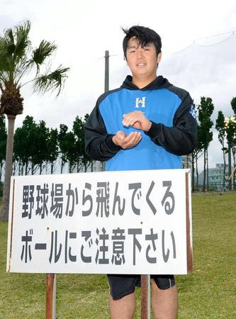 韓国プロ野球の起亜タイガースとのオープン戦で場外３ランを放った日本ハム・横尾俊建。試合後、レフト場外にある看板の前で“おにぎりポーズ”を決める。