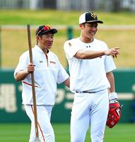 ノック中に一塁方向を指さす巨人・坂本勇人（右）と、それを笑顔で見る石井琢朗コーチ（撮影・高石航平）