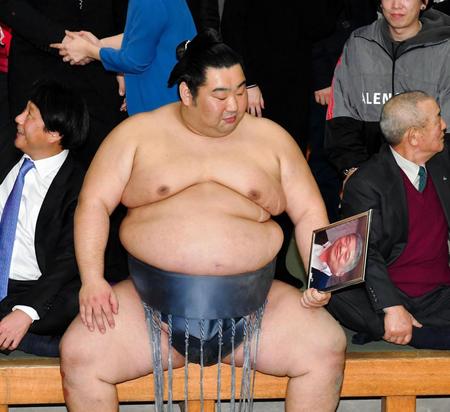 支度部屋でのバンザイを終えた後、恩師の写真をじっと見つめる徳勝龍＝両国国技館（撮影・出月俊成）