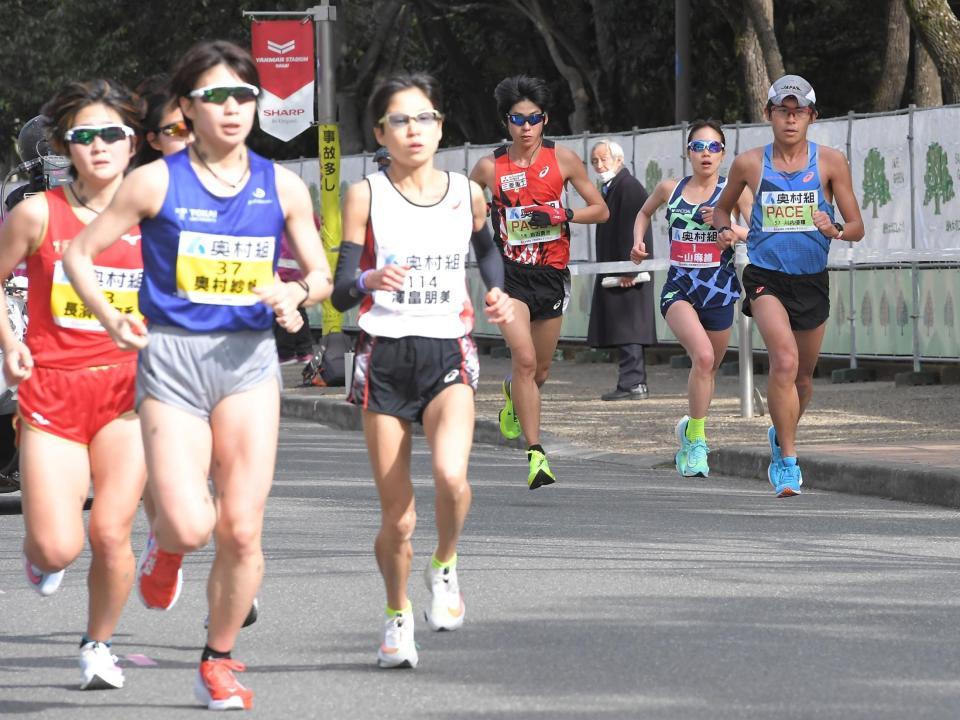 10周目、周回遅れの選手ら（左手前）を横目に力走する一山麻緒（右から２人目）。右端はペースメーカーの川内優輝＝１月31日、長居公園（撮影・高部洋祐）