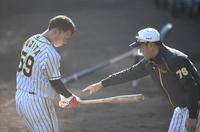 ２月４日、阪神・平野恵一コーチに打撃のアドバイスを受ける阪神・藤田健斗（左）