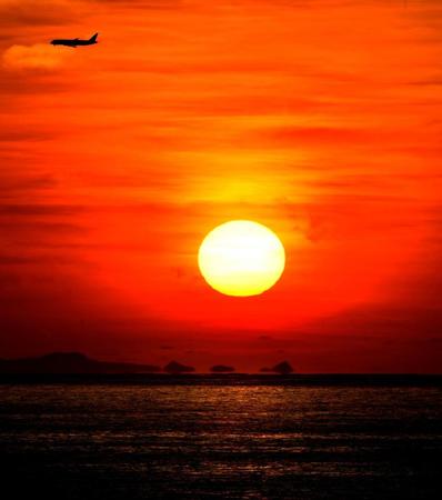 日没、見とれてしまうほどオレンジ色に染まった宮城海岸。“特定席”の滞在先ホテルのテラスから撮影。嘉手納基地から離陸した米軍機が上空を飛ぶ