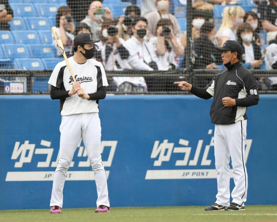 試合前の練習で森脇ヘッドコーチ（右）からノックバットを受け取り、アドバイスに耳を傾けるロッテ・佐々木朗希＝神宮球場（撮影・開出牧）