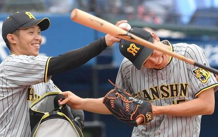 守備練習中に島田（左）から頭をたたかれて笑顔になる阪神・湯浅＝１０日、横浜スタジアム（撮影・堀内翔）