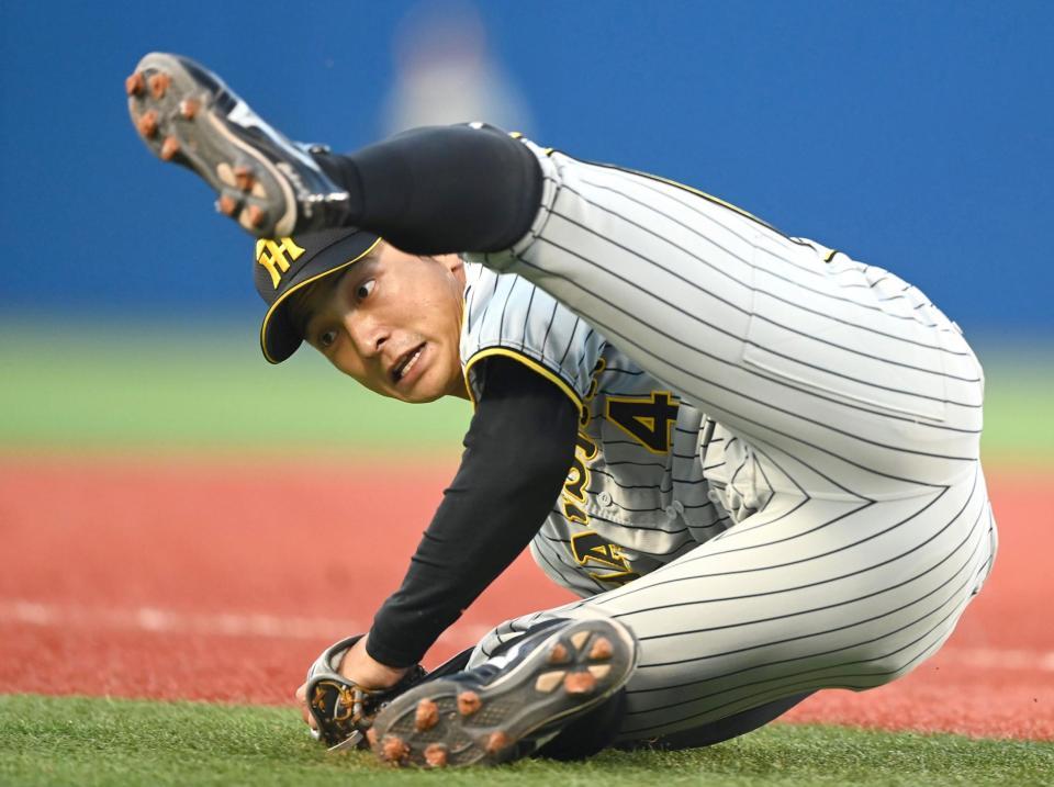 ８回、ＤｅＮＡ・伊藤光の強烈な打球を横っ飛びで好捕する阪神・熊谷敬宥＝１０日、横浜スタジアム（撮影・田中太一）