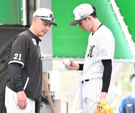 信頼関係をのぞかせる“自然体”。ブルペンで吉井監督（左）にスライダーの握りを見せる佐々木朗（撮影・開出牧）