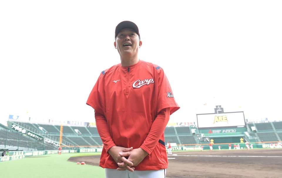 試合前、グラウンド入りし笑顔を見せる広島・新井監督＝18日、甲子園（撮影・高部洋祐）