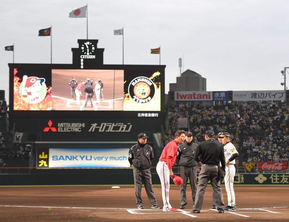 試合前、阪神・岡田監督（右端）とメンバー表交換をする広島・新井監督＝18日、甲子園（撮影・高部洋祐）