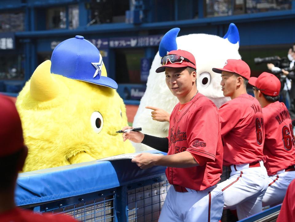 試合前にＤｅＮＡのマスコット・バート＆チャッピーにねだられ、サインを書く広島・大盛穂（中央）＝横浜スタジアム（撮影・伊藤笙子）