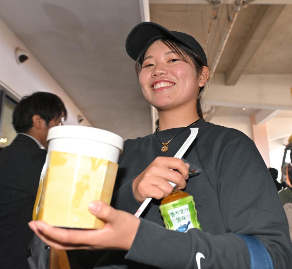 　和田からの差し入れを手に笑顔を見せるプロゴルファーの桜井心那（撮影・中田匡峻）