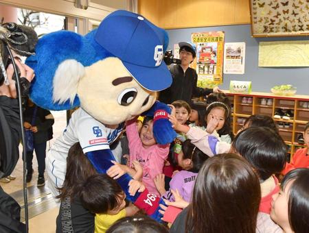 　保育士になれるかも～。キャンプ地の幼稚園を訪れ、園児から熱烈大歓迎を受けるドアラ（左）＝撮影・開出牧