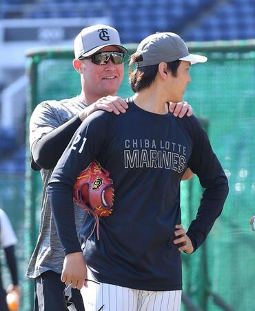 試合前の練習で巨人・リチャード（後方）に肩を揉まれるロッテ・石川柊太＝５日、ＺＯＺＯマリンスタジアム（撮影・開出牧）