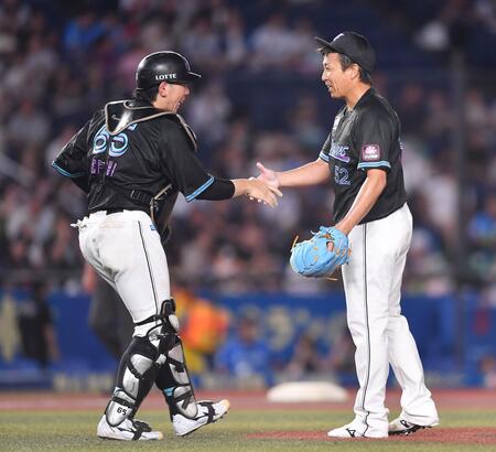 ９回西武２死一塁、渡部聖弥を遊ゴロに打ち取り、最終回を抑えたベテラン守護神の益田直也（右）と握手を交わす寺地隆成＝１３日、ＺＯＺＯマリンスタジアム（撮影・開出牧）