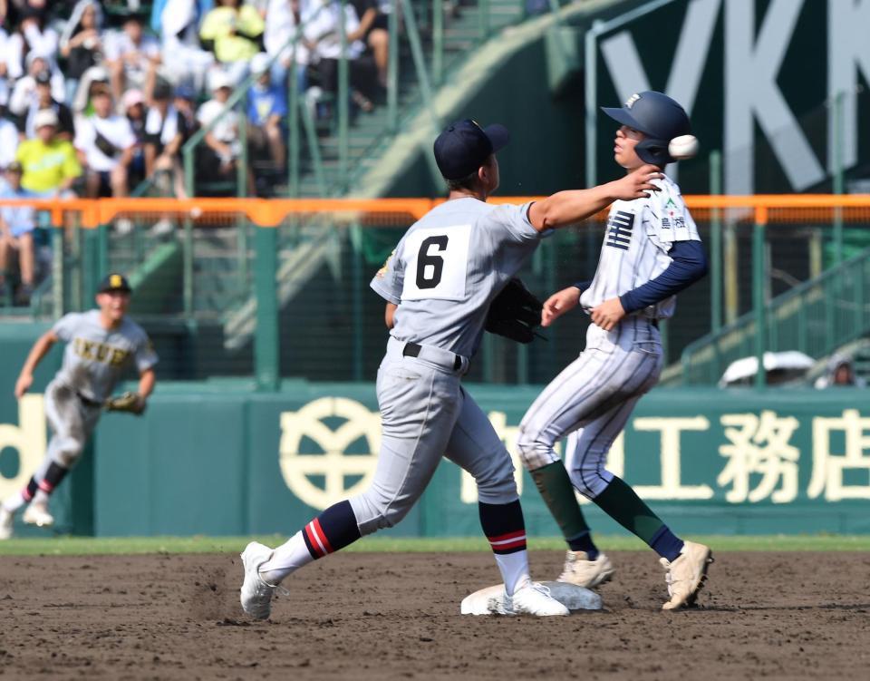 二塁手の有本豪琉の華麗なグラブトスを受け取り、素早く一塁へ送球し併殺プレーを成功させる仙台育英の砂涼人（６）＝甲子園（撮影・開出牧）＝１４日、甲子園（撮影・開出牧）