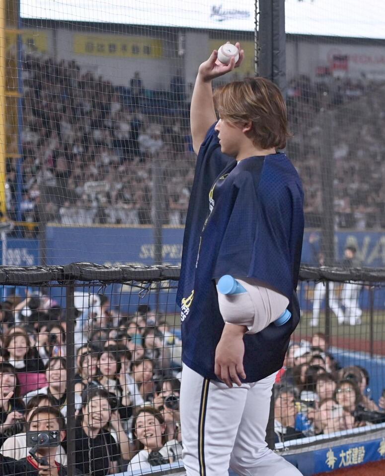 視線の先にロッテファン？フェンスに近寄り狙いを定めてボールを投げ入れるオリックス・宮城大弥＝９日、ＺＯＺＯマリンスタジアム（開出牧）