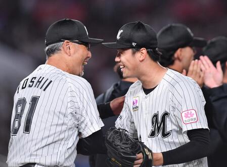 負ければ最下位確定の試合でプロ初完封勝利を挙げ、吉井理人監督（左）と笑顔で握手を交わすロッテ・木村優人＝２４日、ＺＯＺＯマリンスタジアム（撮影・開出牧）