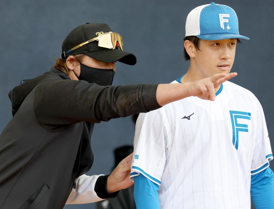 ブルペンで北山（右）にアドバイスする新庄監督＝エナジックスタジアム名護（撮影・西岡正）