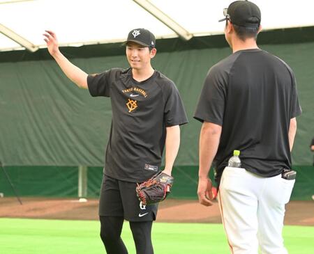 ネット越しにピッチングを見守っていた内海哲也投手コーチ（右）と言葉を交わす巨人・戸郷翔征＝１９日、那覇（撮影・開出牧）