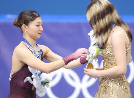 米国のアリサ・リュウ（右）の金メダルにぬいぐるみを飾ってあげる坂本花織＝１９日、ミラノアイススケートアリーナ（撮影・吉澤敬太）