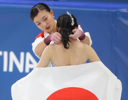 記念撮影時、中井亜美（手前）のメダルを整えてあげる坂本花織＝１９日、ミラノアイススケートアリーナ（撮影・吉澤敬太）