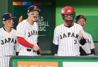 試合前に、ベンチでキャッチャーマスクをかぶる広島・小園海斗。爆笑する阪神・佐藤輝明と坂本誠志郎＝８日（撮影・堀内翔）