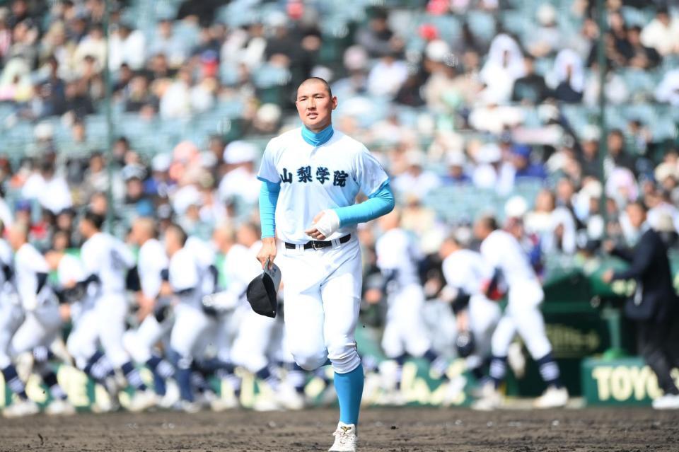 悔しさがにじみ出ていた。校歌を終えて駆け出すナインから遅れてスタンドへ向かう山梨学院の主将・菰田陽生投手＝２６日（撮影・開出牧）