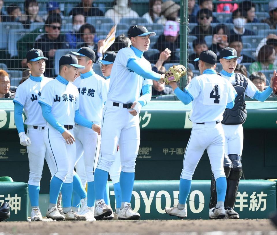 守りを終えたナインを出迎えタッチを交わす山梨学院・菰田陽生（中央）＝２６日（撮影・開出牧）