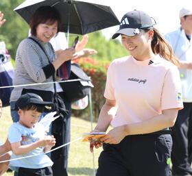 ホールアウト後、子どもからの差し入れを手にクラブハウスへ向かう渋野日向子（右）＝埼玉・石坂ＧＣ（撮影・伊藤笙子）
