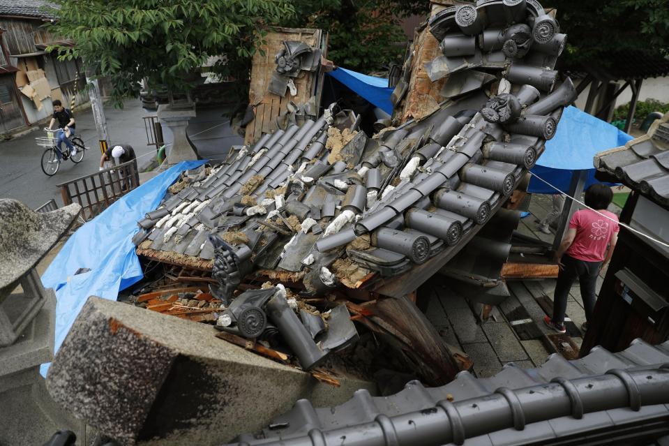 大阪北部地震で倒壊した寺の山門。一部にブルーシートが掛けられていた＝６月１９日午後、大阪府茨木市（提供・共同通信社）