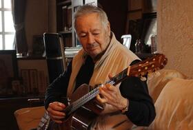 ギターを爪弾くクロード・チアリさん＝西宮市内