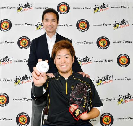 　「チームが輝くように」とボールに輝の一字を書いた西（手前）とデイリースポーツ評論家・中田良弘氏