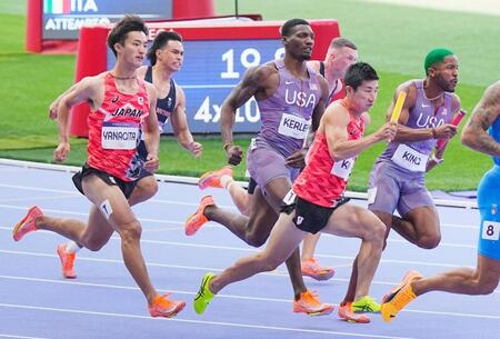 　男子４００メートルリレー予選、第２走者の柳田大輝（左端）からバトンを受け、力走する第３走者の桐生祥秀（共同）