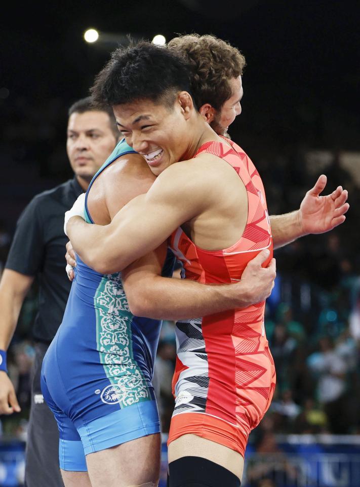 　男子フリー74キロ級決勝で敗れ、ウズベキスタン選手（左）と健闘をたたえ合う高谷大地＝パリ（共同）