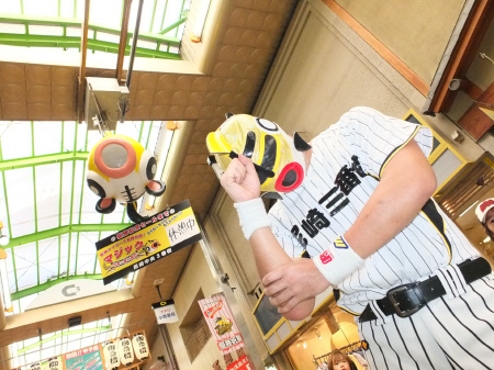 「休憩中」になった阪神優勝マジックボードの前で頭を抱えるめでタイガーマスク＝尼崎市内