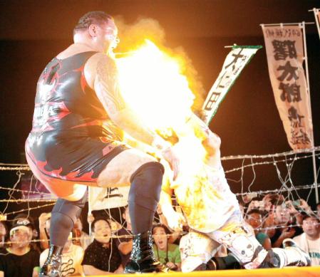 　大仁田厚の火炎攻撃を浴びる曙（左）