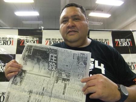 　電流爆破マッチを報じるデイリースポーツを笑顔で手にする曙