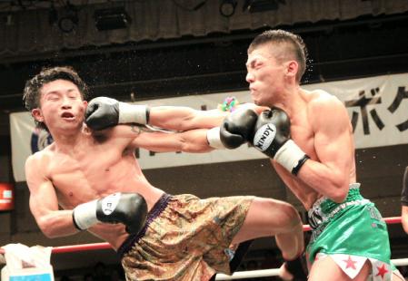 　古河たすくに右ストレートを放つ、内田雅之（右）