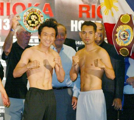 　計量後、ファイティングポーズをとる西岡利晃（左）とノニト・ドネア＝１２日、ロサンゼルス郊外のホテル（共同）